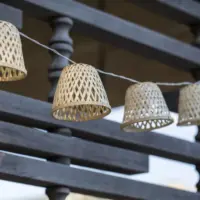 Nahaufnahme Lichterkette Boho. Es sind 4 Lampen im Rattan Korb Stil zu sehen.